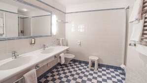 Un baño con dos lavamanos, un inodoro y una ducha.