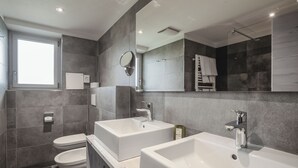 A modern bathroom with two sinks, a toilet, and a large mirror. - Monte Croce Hotel Kreuzberg (Sesto)