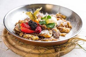 Een nagerechtbord met diverse soorten fruit en een toefje slagroom.
