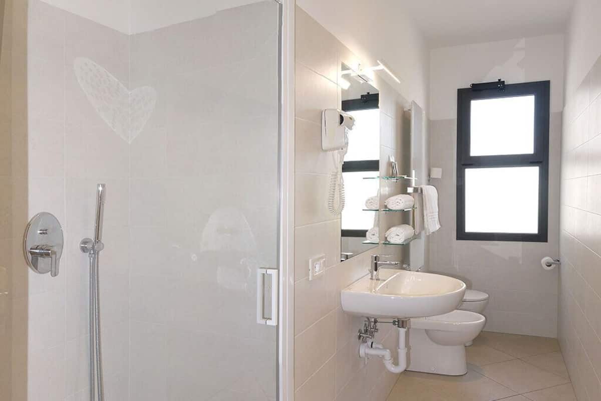 Une salle de bain moderne avec une douche à l’italienne, un lavabo et des toilettes.