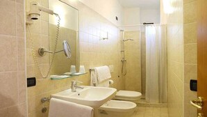 Un baño con lavamanos, inodoro, bidé y ducha.