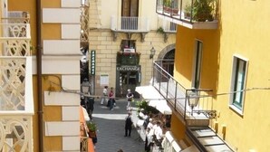 A bustling street scene with a café and a building labeled 'EXCHANGE'. - DolceVita Sorrento Guest House (Sorrento)