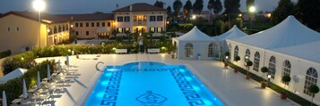 Una piscina al aire libre de temporada, sombrillas