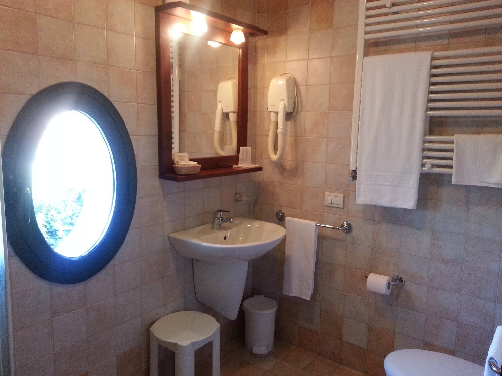 A bathroom with a sink, mirror, towel rack, and toilet.