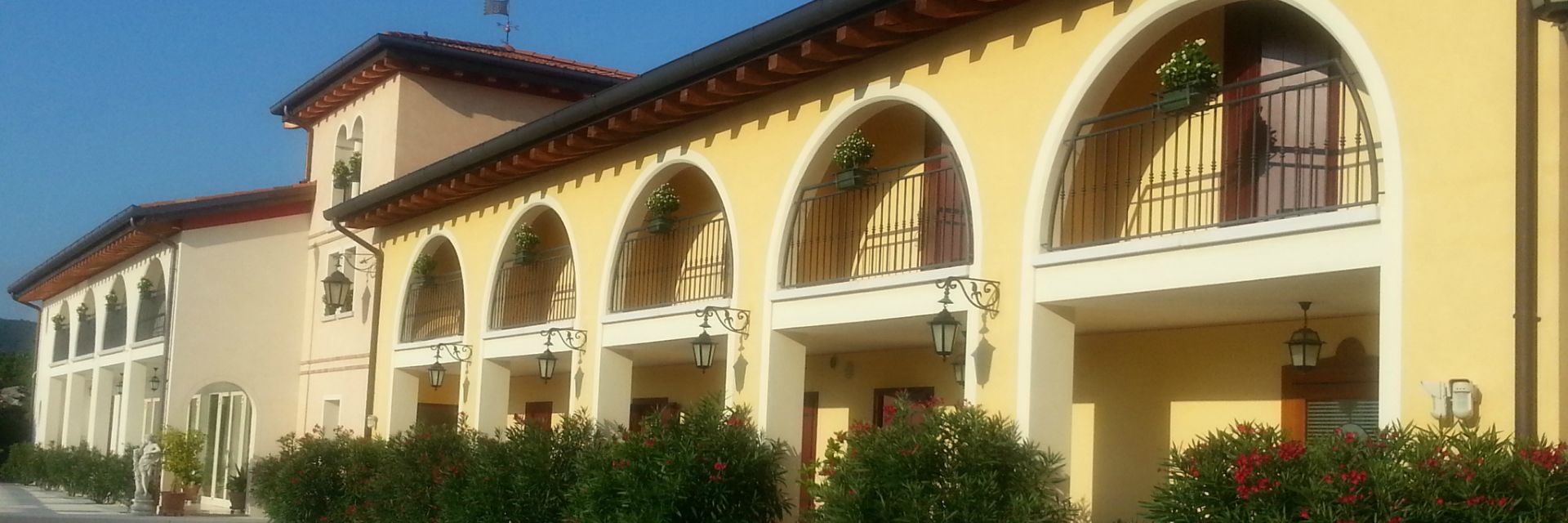 A building with multiple balconies, arched windows, and a tiled roof.