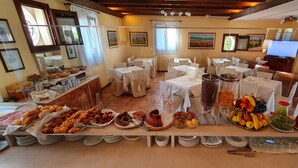 Un buffet proposant une variété de plats et des tables disposées dans un espace dédié à la restauration.