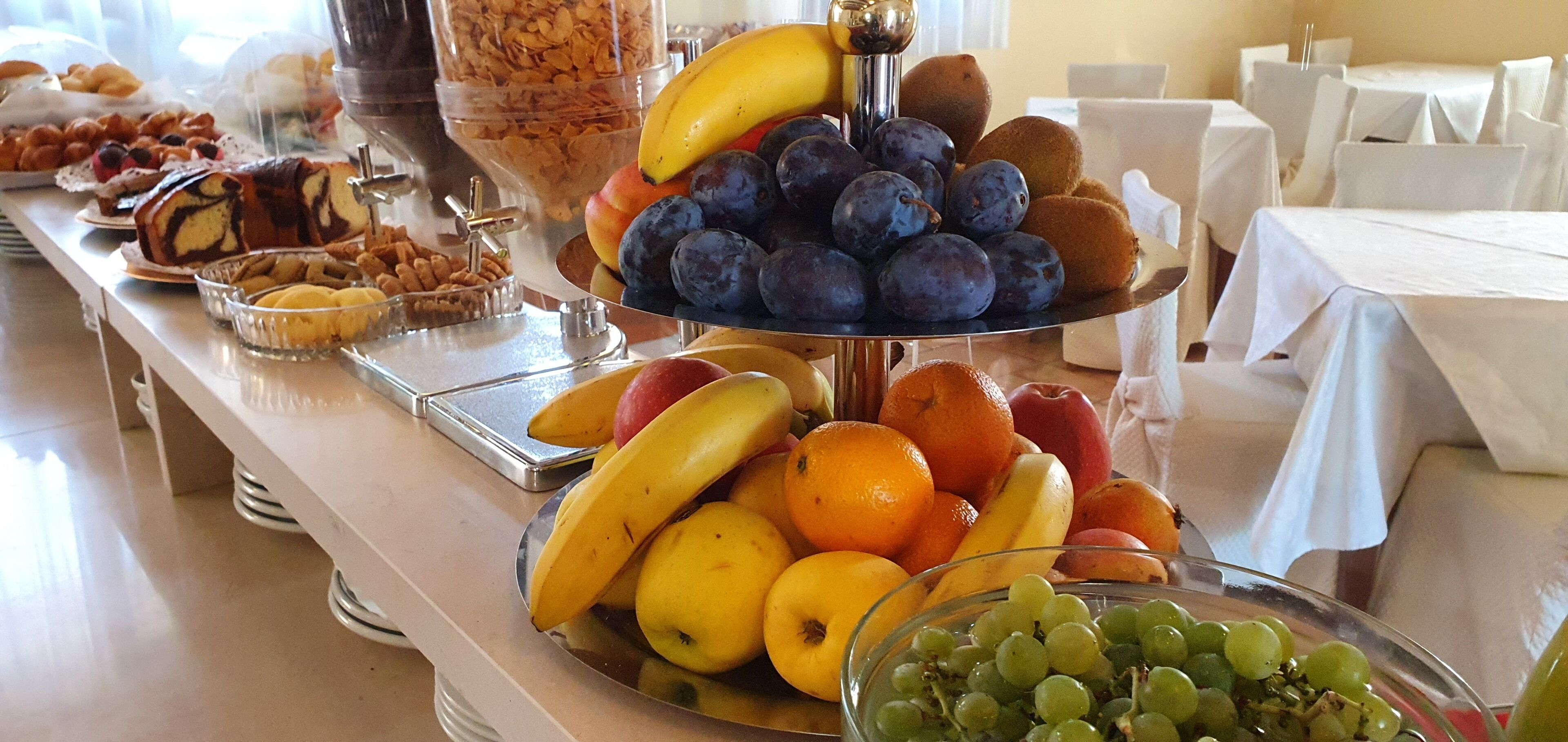 A buffet with various fruits and pastries.