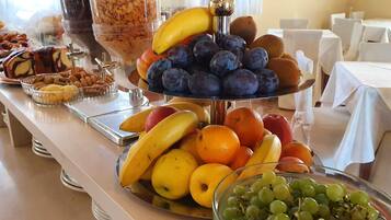 Un buffet proposant une variété de fruits et de pâtisseries.