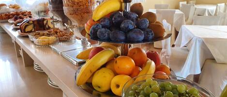 Un buffet proposant une variété de fruits et de pâtisseries.