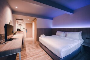 A hotel room with a bed, bedside table, TV, and a bathroom visible in the background. - The Green View (Pattaya)