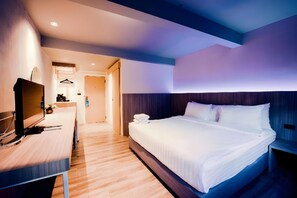 A hotel room with a bed, bedside table, TV, and a bathroom visible through an open door. - The Green View (Pattaya)