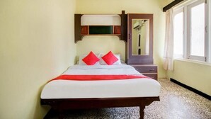 A bedroom with a bed, a mirror, a wardrobe, and a window. - Gaffino's Beach Resort (Cavelossim)