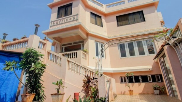 A multi-story building with a flat roof, balconies, and potted plants. - Gaffino's Beach Resort (Cavelossim)