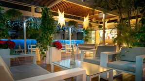 A modern outdoor seating area with white furniture, star-shaped lights, and greenery. - Vanilla Garden Boutique Hotel - Adults Only (Arona)