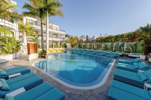 A swimming pool with lounge chairs, a water feature, and a building with balconies. - Vanilla Garden Boutique Hotel - Adults Only (Arona)