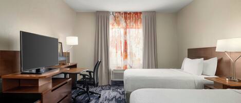 A hotel room with a flat-screen TV, a desk with a chair, two beds with white bedding, a window with curtains, and a lamp on each side of the bed.