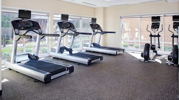 A gym with treadmills, exercise bikes, and weight machines.