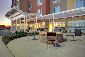 An outdoor patio with a stone fire pit and seating. - TownePlace Suites by Marriott Albany (Albany)