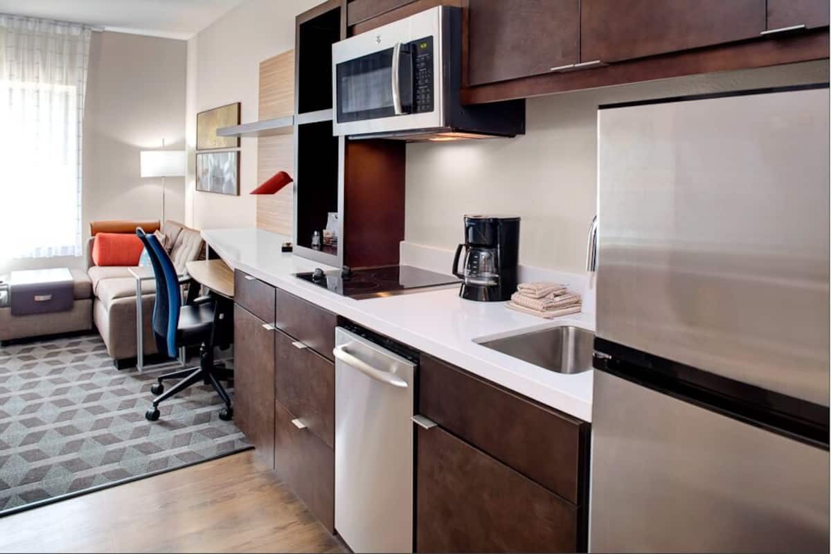 A compact kitchen with a microwave, coffee maker, and a dishwasher.