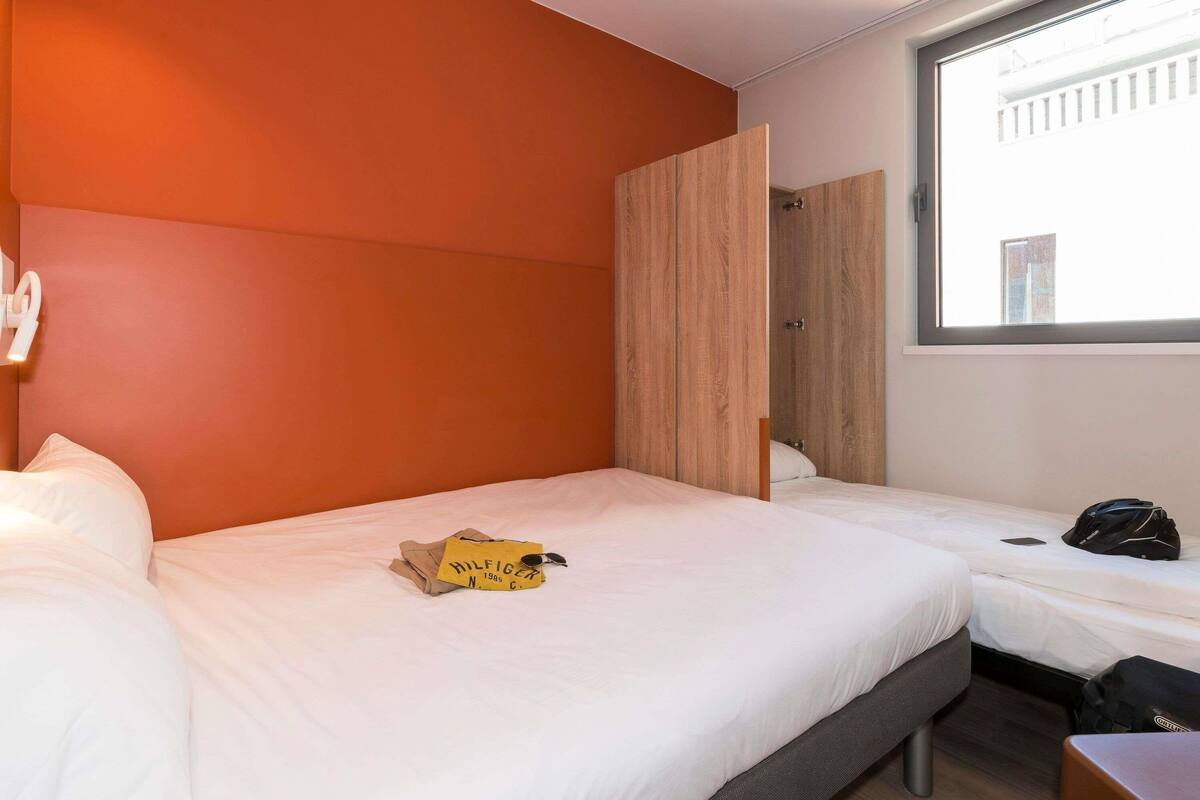 Habitació d'hotel amb llit, maleta i finestra amb vista.