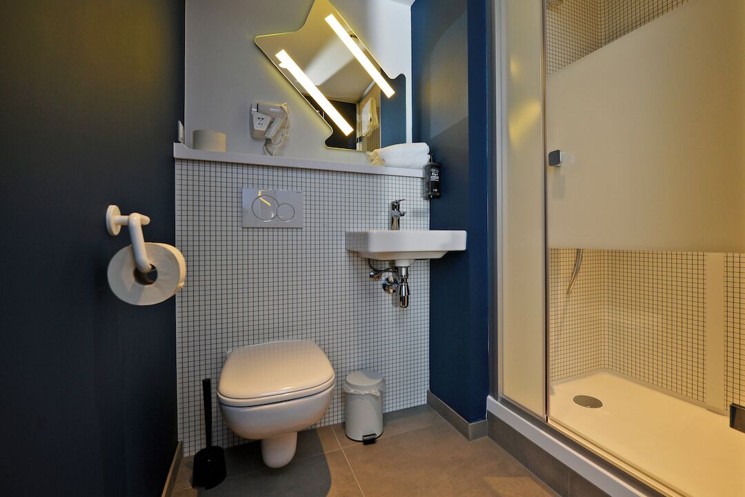 A modern bathroom with a toilet, sink, and shower.