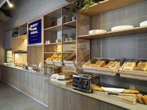 Un bufé de desayuno con diversas opciones de comida y un tostador.