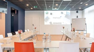 Een vergaderruimte met een lange tafel, stoelen, een whiteboard en een projectiescherm waarop 'digitopia' staat.