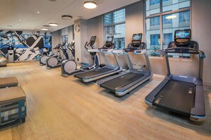 A gym with treadmills, ellipticals, and a wall mural. - Residence Inn by Marriott Baltimore at The Johns Hopkins Medical Campus (Baltimore)