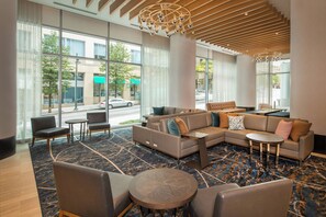 A modern hotel lobby with a sectional sofa, armchairs, a round coffee table, and a patterned carpet. - Residence Inn by Marriott Baltimore at The Johns Hopkins Medical Campus (Baltimore)