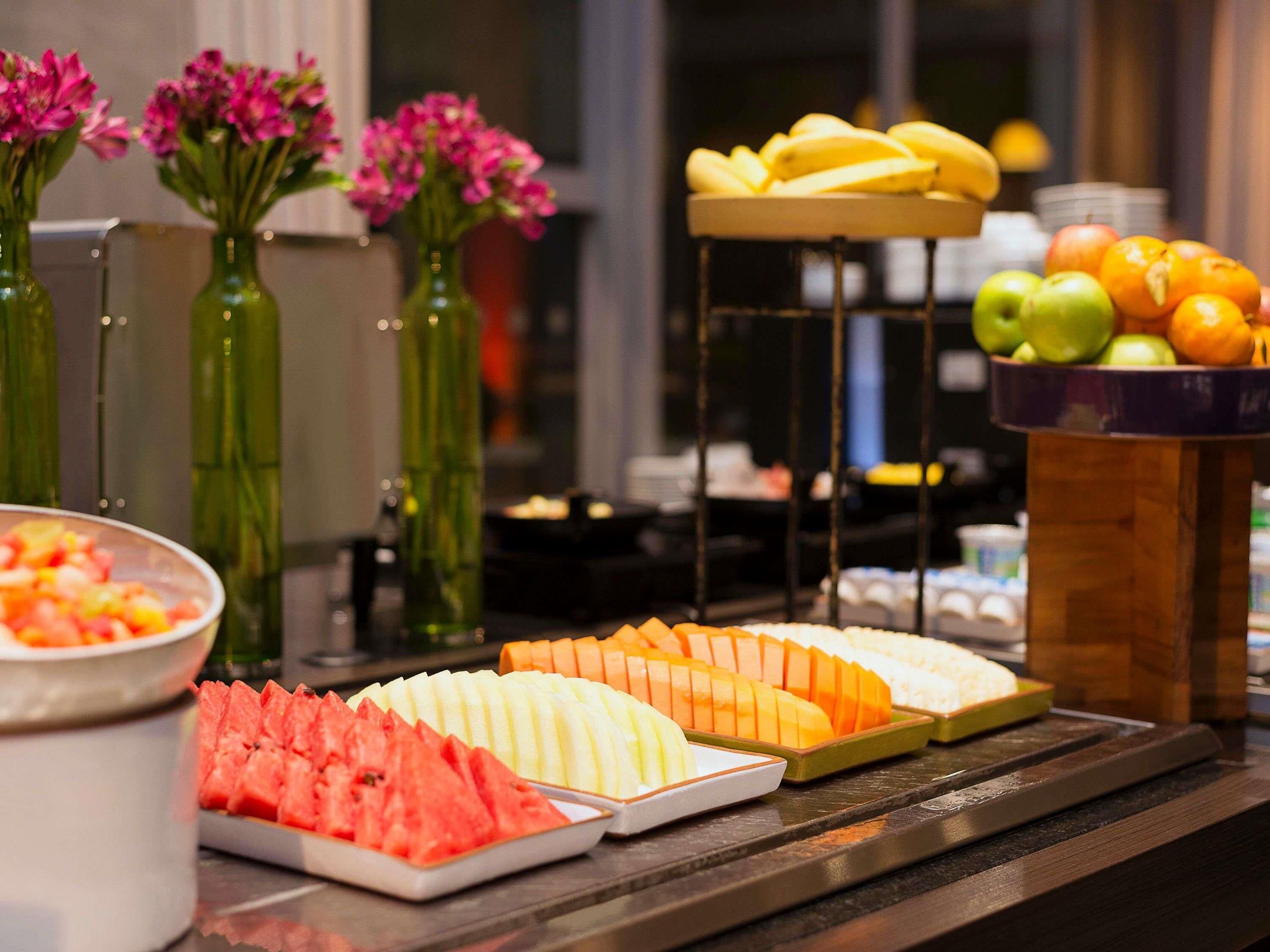 Un bufé con diversas frutas y verduras, incluyendo sandía, melón y manzanas.
