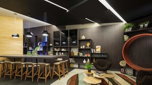 A modern kitchen with a bar area, wooden stools, and a variety of decorative items on shelves. - Novotel São Paulo Berrini (São Paulo)