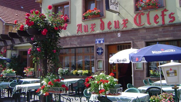 A hotel named "Auerdeux Clevs" with outdoor seating and flower arrangements. - Hotel aux deux clefs (Marmoutier)