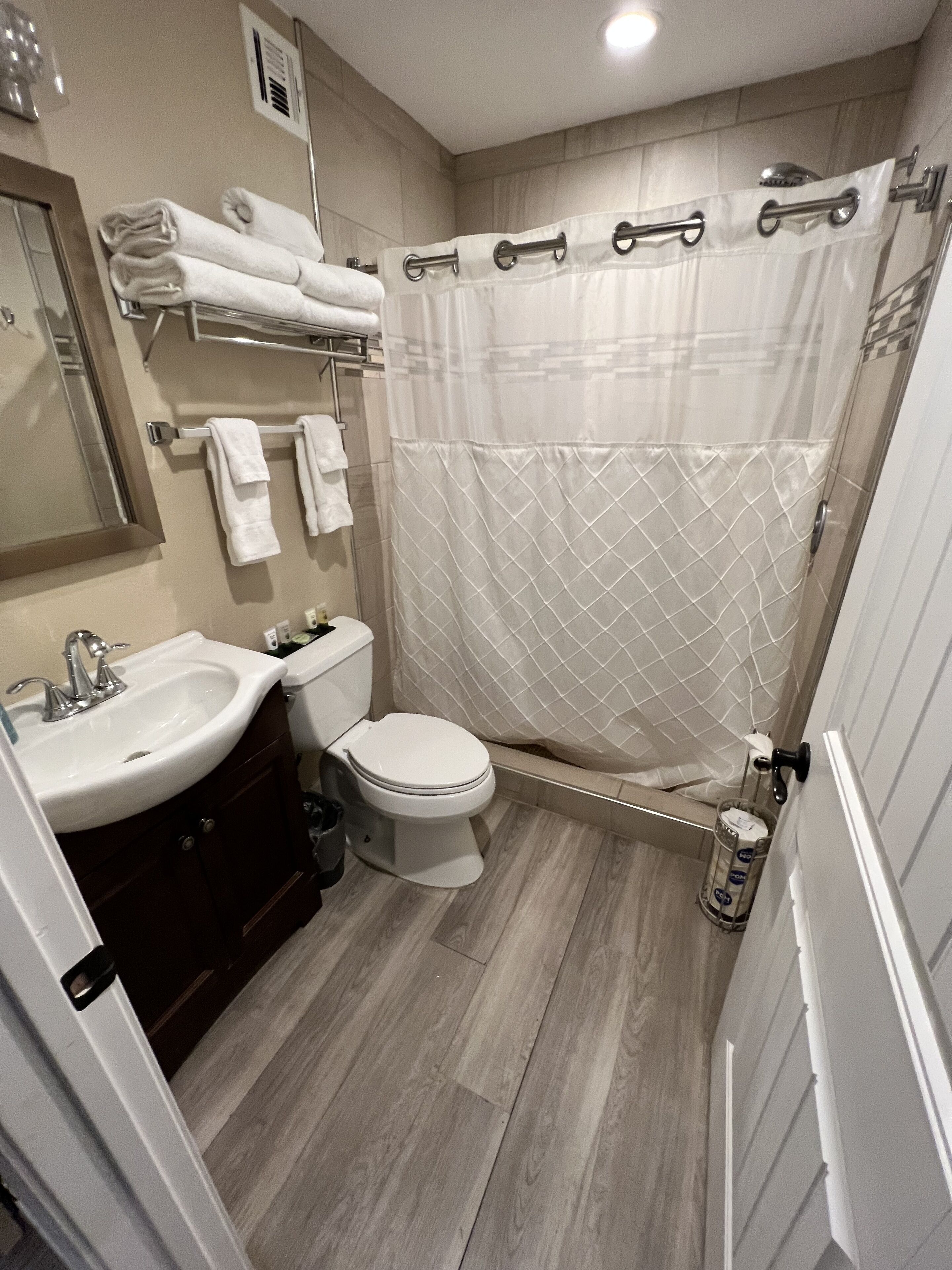 Une salle de bain moderne équipée d’un lavabo, de toilettes et d’une douche.