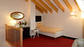 Een slaapkamer met een bed, een kaptafel, een spiegel, een klein tafeltje met een lamp en een raam met uitzicht.