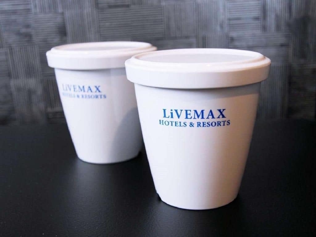 Two white disposable cups with 'Livemax Hotels & Resorts' branding.