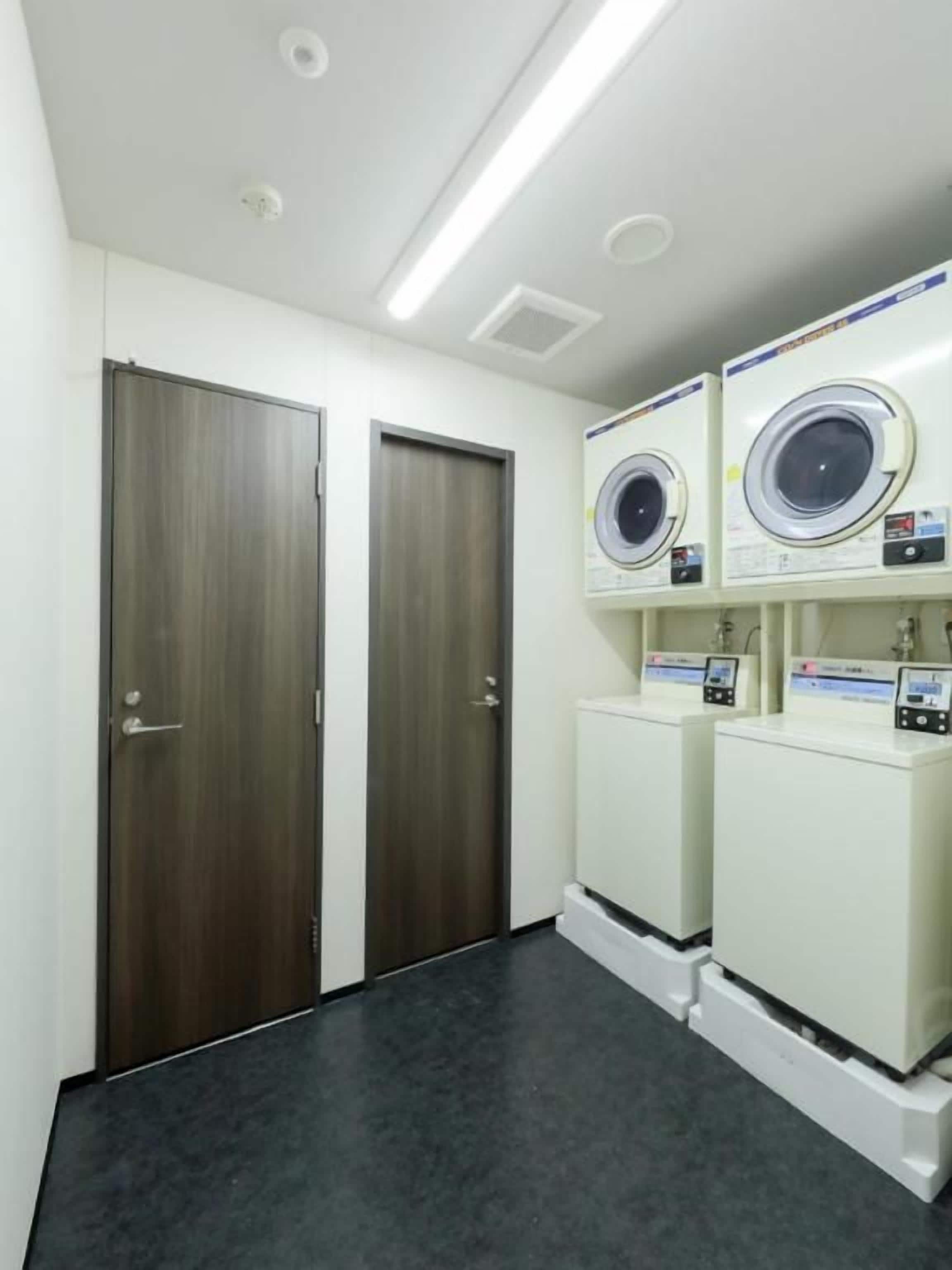 A laundry room with two doors, a washing machine, and a dryer.