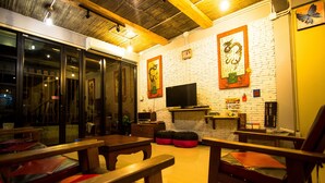 A cozy interior with wooden furniture, a flat-screen TV, and a brick wall.