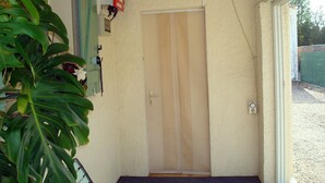 Una habitación con puerta corredera, una mesita y una planta en maceta.