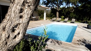 A rectangular swimming pool with a wooden deck, surrounded by lounge chairs and a pergola. - STE LUCIE DE PORTO VECCHIO villa / heated pool (classified ****) (Zonza)
