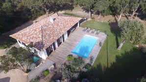 A house with a tiled roof, a swimming pool, and a wooden deck.