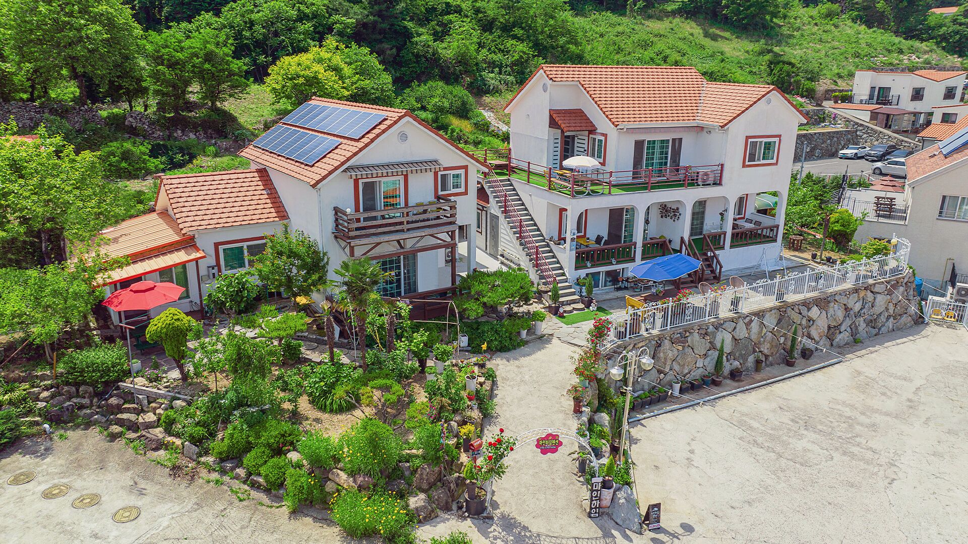 Un hotel costero con varias edificaciones, mobiliario exterior y paneles solares.