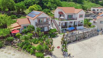 Un hotel costero con varias edificaciones, mobiliario exterior y paneles solares.
