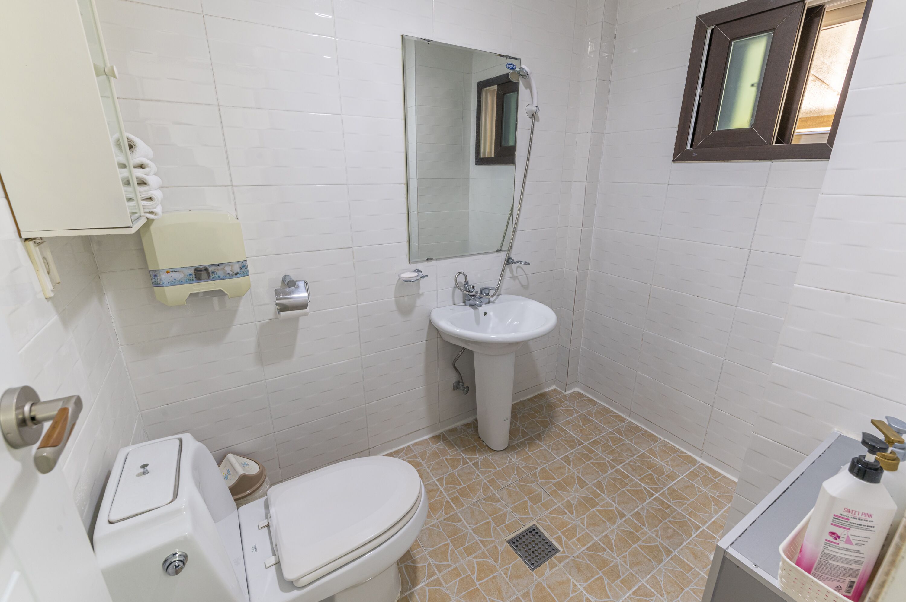 Un baño con inodoro, lavamanos y ducha.