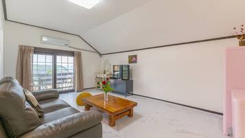 A modern living room with a sofa, a wooden coffee table, and a TV.