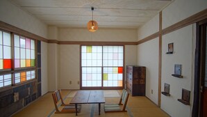 A traditional Japanese room with tatami flooring, a low table, and shoji screens. - Hakuba Station Guest House Hostel eN (Hakuba)