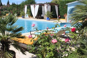 A pool area with lounge chairs and a gazebo. - Atypical house in the south of Provence near Avignon, 4 persons   (Carpentras)