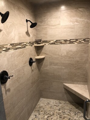 A small, tiled shower area with a built-in shelf and a handheld showerhead. - Beautiful Ozarks retreat on Bull Shoals Lake (Lakeview)