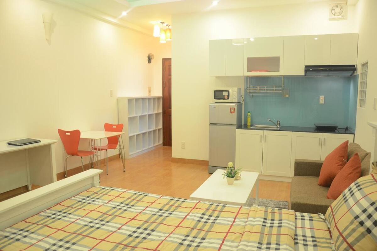 A compact living space with a kitchenette, a dining area, and a sofa.