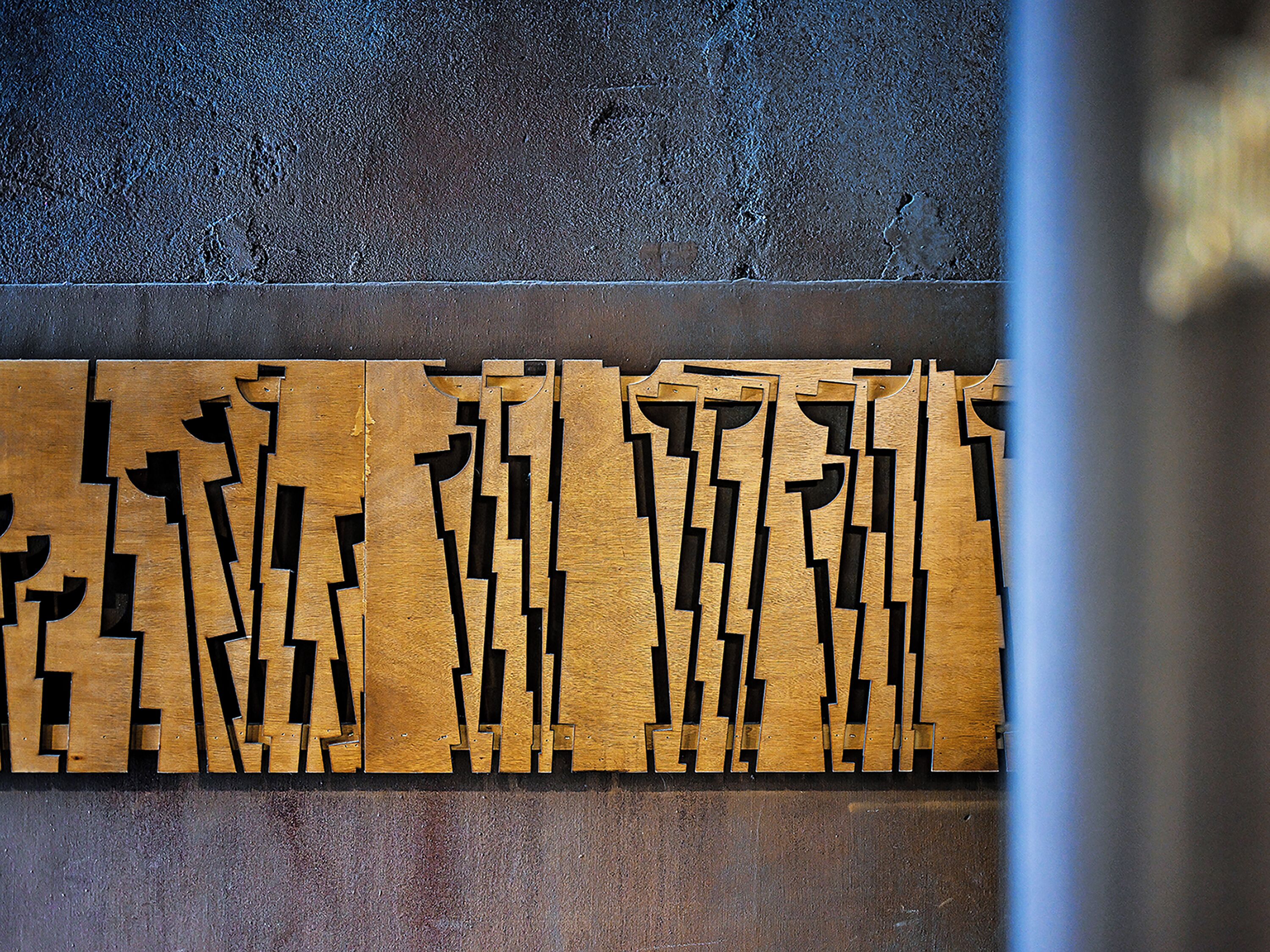Una pared con diseño geométrico de paneles de madera.
