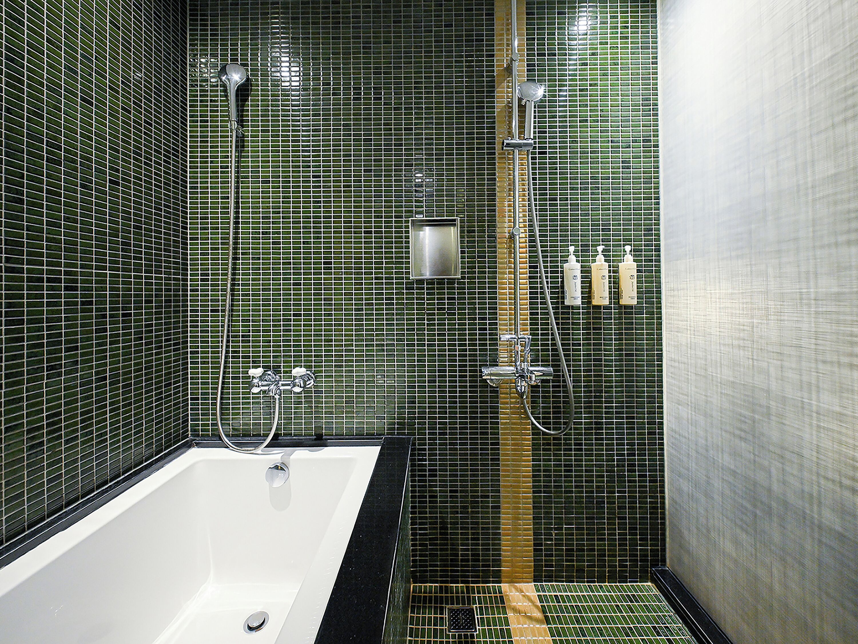 Un baño con bañera, ducha y paredes de azulejos.